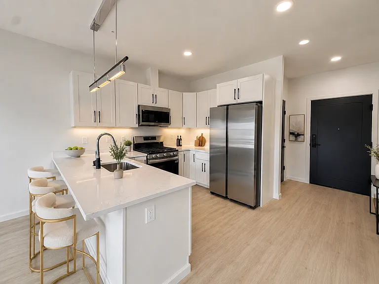 Kitchen with an island and white cabinetry in the Van Houten Street project. Kitchen with an island and white cabinetry in the Van Houten Street project.
